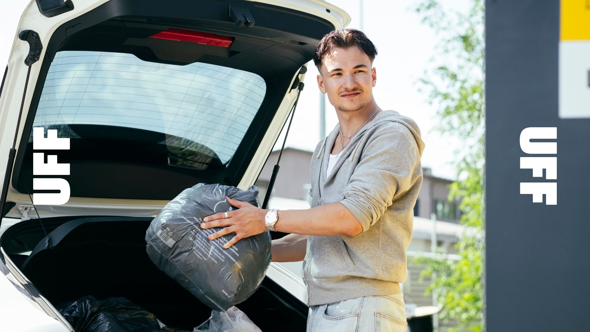 Henkilö ottamassa vaatelahjoituskassia auton peräkontista.